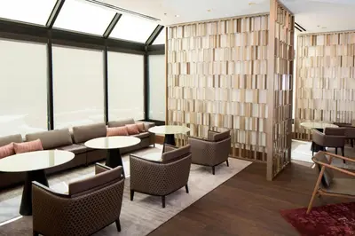 a restaurant with tables and chairs and windows at Hanover Marriott in Whippany