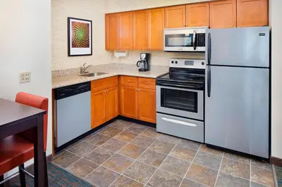 a kitchen with stainless steel appliances and wooden cabinets at Residence Inn by Marriott Saddle River in Saddle River