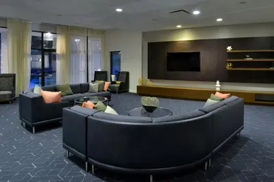 a living room with couches and a flat screen tv at Courtyard by Marriott Harrisburg Hershey in Harrisburg