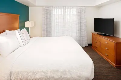 a bedroom with a large white bed and a flat screen tv at Residence Inn by Marriott Harrisburg Hershey in Harrisburg