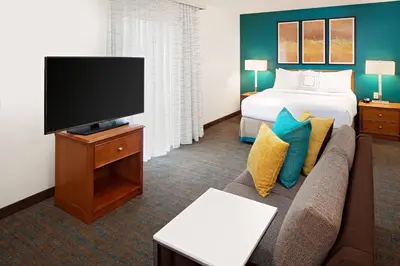 a hotel room with a bed and a couch and a tv at Residence Inn by Marriott Harrisburg Hershey in Harrisburg