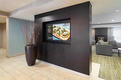 a living room with a television on a wall at Courtyard by Marriott Princeton in Princeton