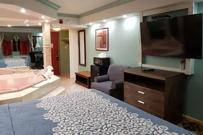 a large bathroom with a tub and a tv and a bedroom at Days Inn by Wyndham Nanuet / Spring Valley in Nanuet