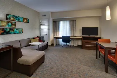 a hotel room with a couch and a desk with a television at Residence Inn by Marriott Philadelphia Valley Forge/Collegeville in Collegeville