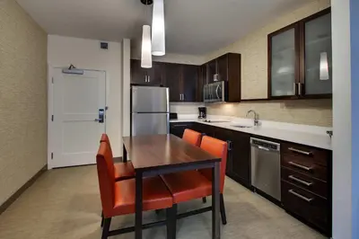a kitchen with a wooden table and orange chairs at Residence Inn by Marriott Philadelphia Valley Forge/Collegeville in Collegeville