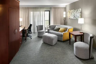 a hotel room with a couch and a chair and a desk at Courtyard Bethlehem Lehigh Valley/I-78 in Bethlehem