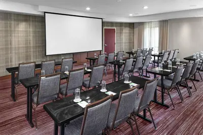 a conference room with tables and chairs and a screen at Courtyard Bethlehem Lehigh Valley/I-78 in Bethlehem
