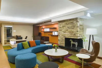 a living room with a blue couch and a fireplace at Best Western Allentown Bethlehem Lehigh Valley Inn & Suites in Bethlehem