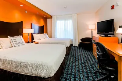 a hotel room with two beds and a desk at Fairfield by Marriott Wilkes-Barre in Wilkes-Barre