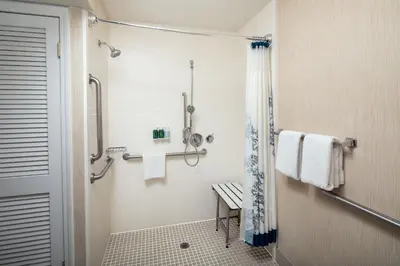 a bathroom with a shower and a toilet with towels at Residence Inn Binghamton in Vestal