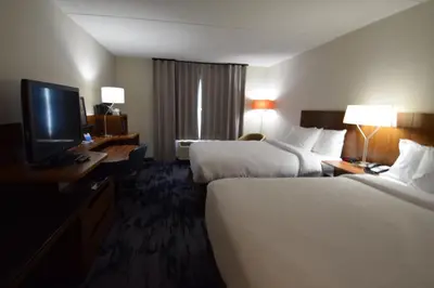 a hotel room with two beds and a flat screen tv at Fairfield Inn by Marriot Binghamton in Binghamton