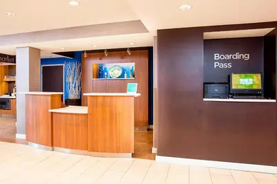 a waiting room with a boarding pass sign on a wall at Courtyard Binghamton in Vestal