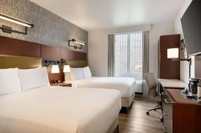 a hotel room with two beds and a desk at DoubleTree by Hilton New York Downtown in New York