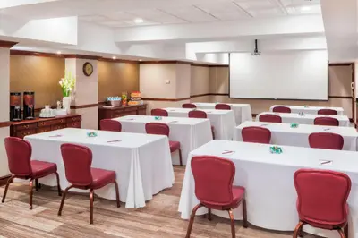 a conference room with white tables and red chairs at Residence Inn by Marriott West Orange in West Orange