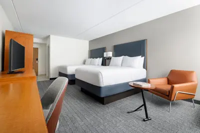 a hotel room with a bed and a chair at Courtyard Montvale in Montvale