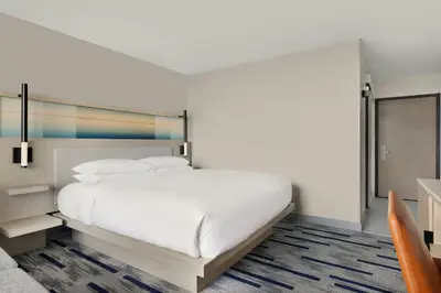 a bedroom with a large white bed and a chair at Marriott Saddle Brook in Saddle Brook