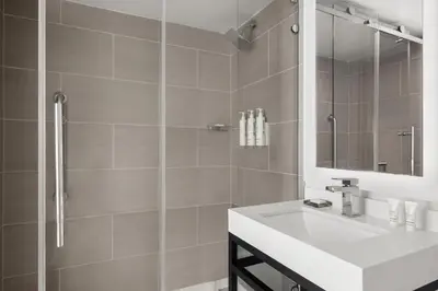 a bathroom with a white sink and a shower at Marriott Saddle Brook in Saddle Brook