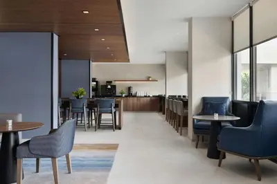a restaurant with tables and chairs and a kitchen at Marriott Saddle Brook in Saddle Brook