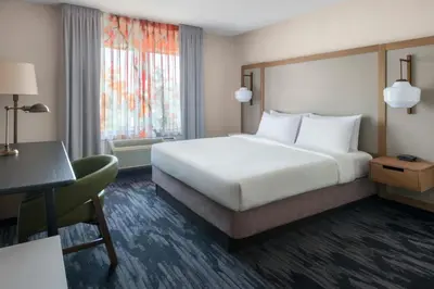 a hotel room with a large bed and a desk at Fairfield Inn & Suites Woodbridge in Avenel