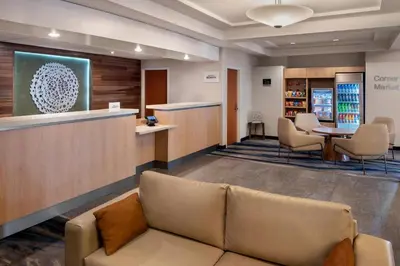 a waiting room with a couch and a bar at Fairfield Inn & Suites Woodbridge in Avenel