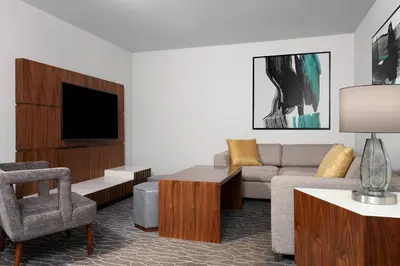 a living room with a couch and a tv at Delta Hotels by Marriott Woodbridge in Iselin