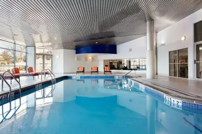 a swimming pool with blue water in a building at Delta Hotels by Marriott Woodbridge in Iselin