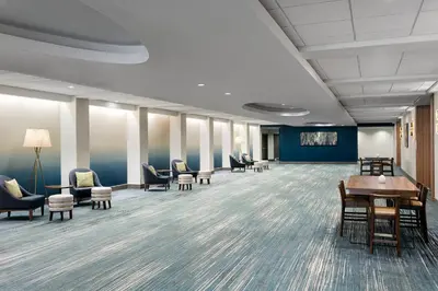 a waiting room with chairs and tables in a building at Delta Hotels by Marriott Woodbridge in Iselin