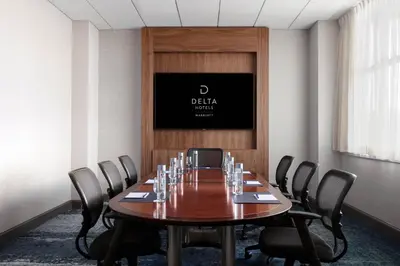 a conference room with a wooden table and chairs at Delta Hotels by Marriott Woodbridge in Iselin