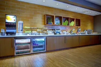 a restaurant kitchen with a counter with food at SpringHill Suites Harrisburg Hershey in Harrisburg