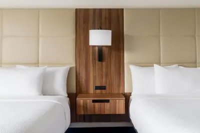 two beds in a hotel room with a lamp between them at Fairfield Inn Harrisburg Hershey in Harrisburg