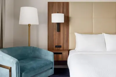 a bedroom with a bed and a chair and a lamp at Fairfield Inn Harrisburg Hershey in Harrisburg
