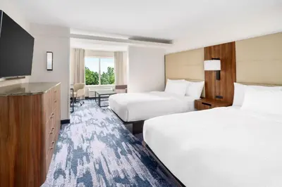 a hotel room with two beds and a flat screen tv at Fairfield Inn Harrisburg Hershey in Harrisburg