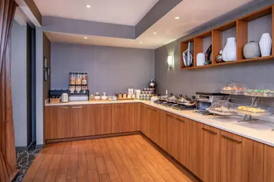 a kitchen with wooden cabinets and a counter with food at SpringHill Suites by Marriott Hershey Near The Park in Hershey