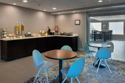a waiting room with two tables and blue chairs at TownePlace Suites Wilmington Newark / Christiana in Newark