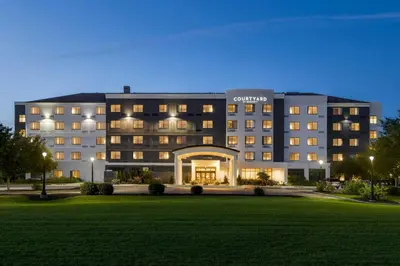 a hotel building with a lawn in front of it at Courtyard Lancaster in Lancaster