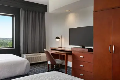a hotel room with a desk with a tv and a bed at Courtyard Lancaster in Lancaster
