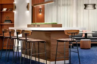 a bar with stools around a counter in a room at Courtyard Lancaster in Lancaster