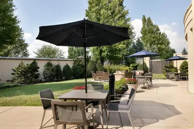 a table and chairs with an umbrella on a patio at Courtyard Lancaster in Lancaster