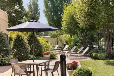 a row of tables and chairs with an umbrella at Courtyard Lancaster in Lancaster