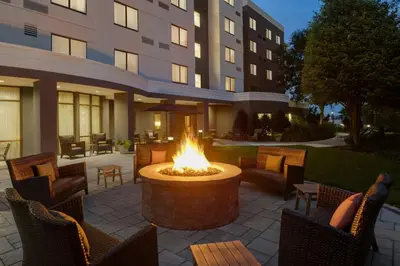 a fire pit in front of a building with chairs and tables at Courtyard Lancaster in Lancaster