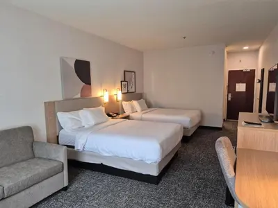 a hotel room with two beds and a couch at Spark by Hilton Lancaster in Lancaster