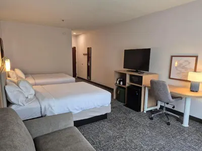 a hotel room with a bed and a desk with a tv at Spark by Hilton Lancaster in Lancaster