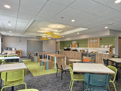 a dining room with tables and chairs and a cafeteria at Spark by Hilton Lancaster in Lancaster