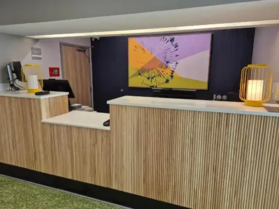 an office lobby with a large tv on the wall at Spark by Hilton Lancaster in Lancaster
