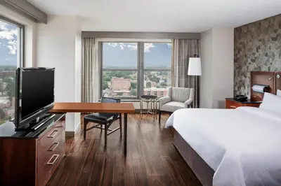 a hotel room with a bed and a desk with a television at Lancaster Marriott at Penn Square in Lancaster