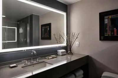 a bathroom with a sink and a large mirror at Lancaster Marriott at Penn Square in Lancaster