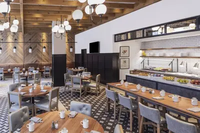 a restaurant with wooden tables and chairs and a buffet at Lancaster Marriott at Penn Square in Lancaster