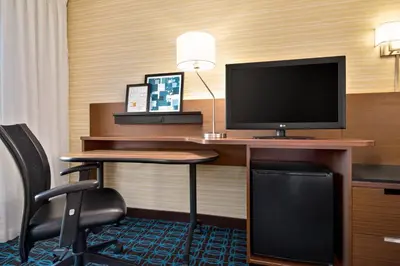 a hotel room with a desk with a computer and a television at Fairfield Inn by Marriott Philadelphia West Chester/Exton in Exton