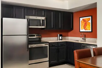 a kitchen with black cabinets and stainless steel appliances at Residence Inn Philadelphia Conshohocken in Conshohocken