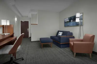 a waiting room with a blue couch and a chair at Courtyard Philadelphia Great Valley/Malvern in Malvern